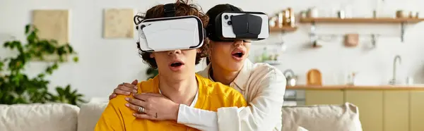 Man and woman share excitement while immersed in a virtual world at home during a cozy evening. — Stock Photo