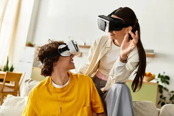 Two individuals experience virtual reality together, smiling and sharing laughter in their home. — Stock Photo