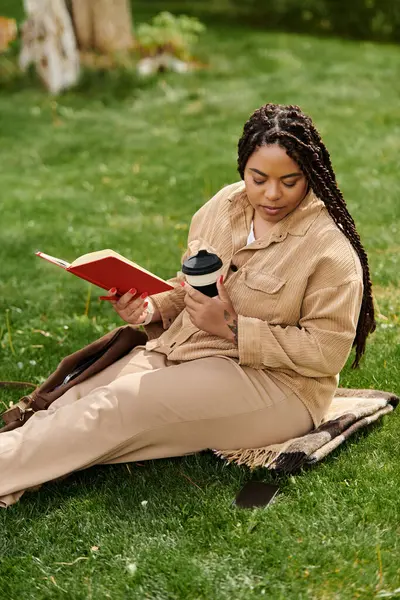 Woman relaxing on grass with a book and coffee cup, reflecting her passion for teaching. — Stock Photo