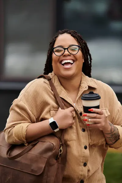 A joyful university teacher holds a coffee cup and beams with happiness while walking outdoors. — Stock Photo