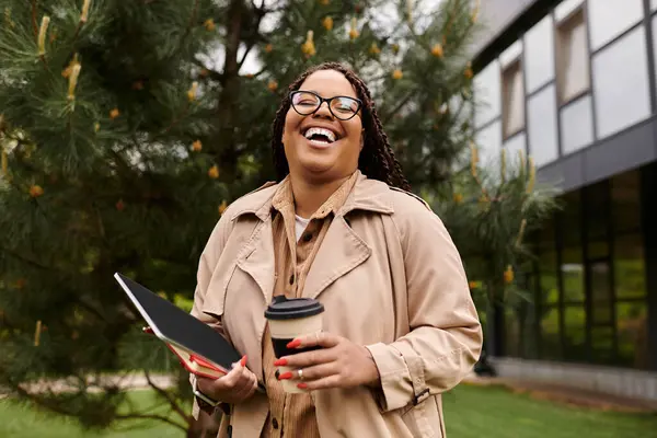 University teacher shares a delightful moment on campus, balancing a tablet and coffee cup. — Stock Photo