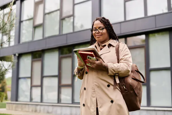 A university teacher reads on a tablet outside, enjoying the nice weather on campus. — Stock Photo