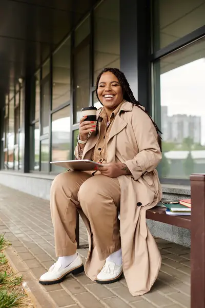 Educator relaxes on a bench, sipping coffee while reviewing notes in a university setting. — Stock Photo