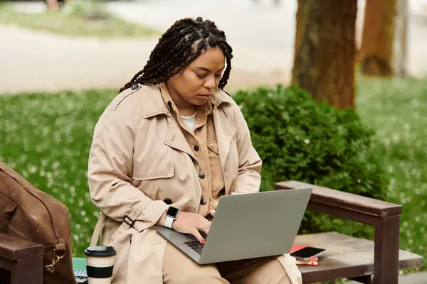 Engaged university teacher works on her laptop in a serene outdoor setting surrounded by greenery. — Stock Photo