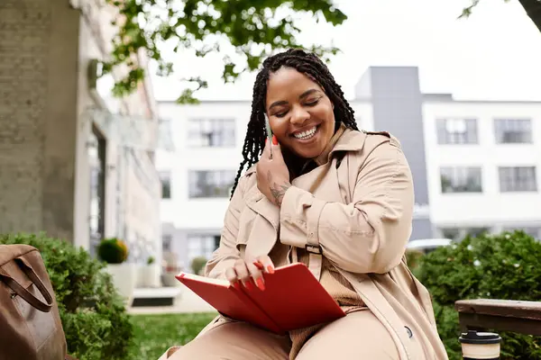 A joyful university teacher reads in a lively outdoor spot, surrounded by greenery. — Stock Photo