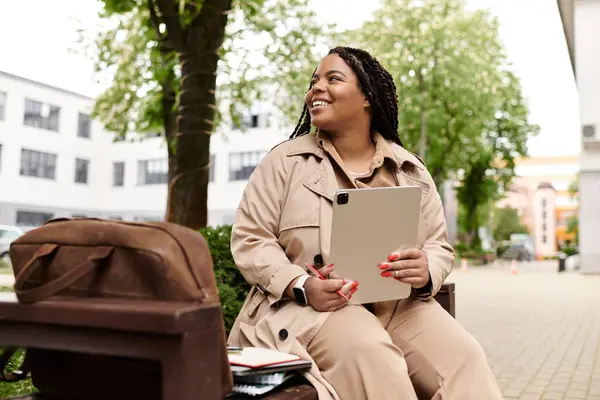 University teacher sits on a bench, smiling while preparing lessons outdoors in spring sunshine. — Stock Photo