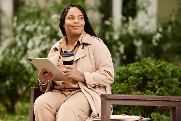 A university teacher relaxes on a bench with a tablet and coffee, immersed in reflective thought. — Stock Photo