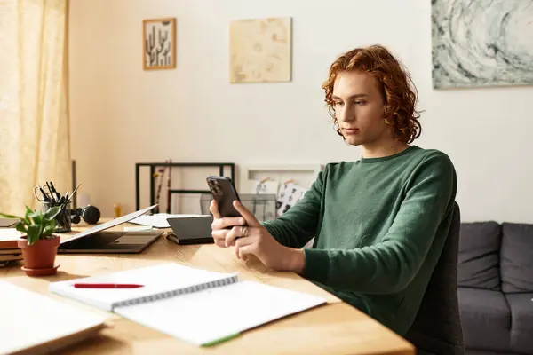 Un giovane uomo si rilassa a casa, concentrato sul suo smartphone con un'espressione calma. — Foto stock