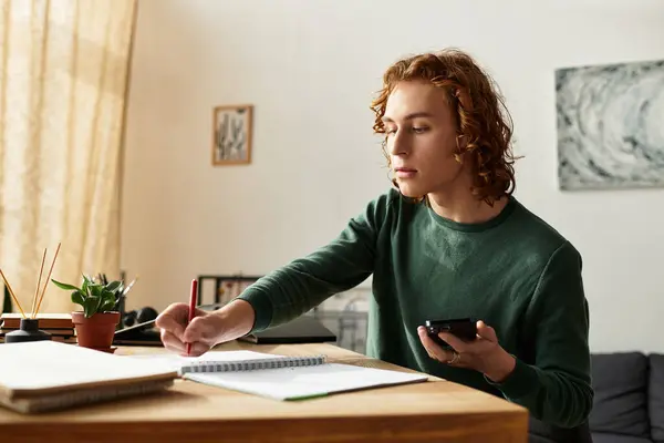 Young man engages in study and creativity, balancing work and comfort in his inviting home setting. — Stock Photo