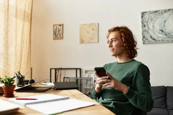 A young man relaxes at home, smiling and focused on his smartphone during a calm afternoon. — Stock Photo