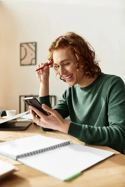 Un giovane uomo rilassato si impegna con il suo telefono a casa, mostrando uno stile di vita accogliente e creatività.. — Stock Photo