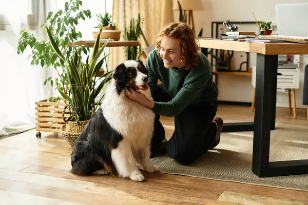 Um jovem está brincando com seu cachorro em um quarto confortável cercado por vegetação e luz natural. — Fotografia de Stock