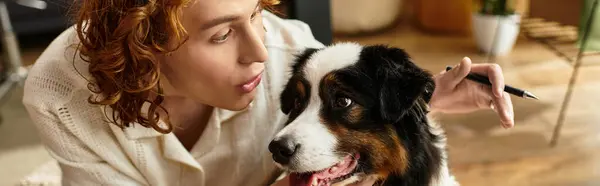 Un giovane uomo e il suo cane condividono una calda interazione in un confortevole spazio abitativo pieno di luce. — Foto stock