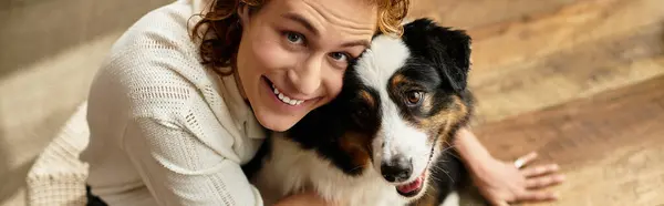 A young man embraces his dog in a warm and cozy home, creating a heartwarming moment of joy. — Stock Photo