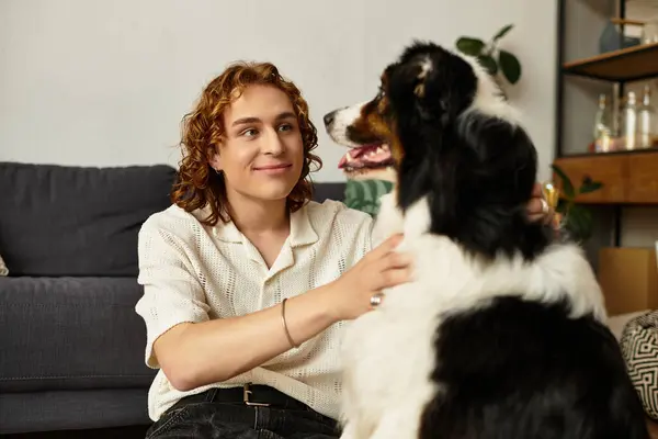 Un giovane condivide un momento gioioso con il suo cane in un ambiente familiare caldo e invitante. — Foto stock