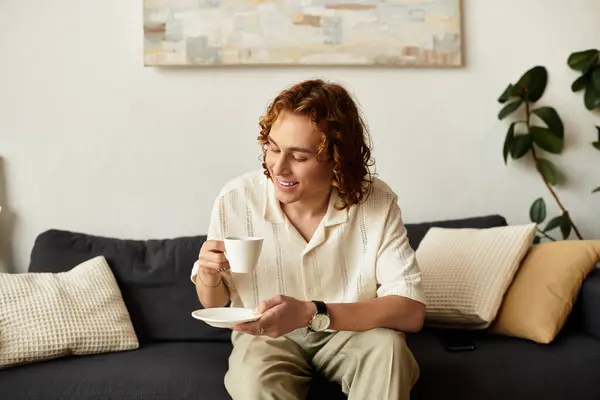 Young man enjoys a warm beverage at home, surrounded by comfort and calmness. — Stock Photo