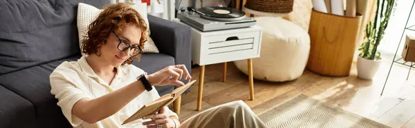 Young man relaxes on a couch, flipping through cherished memories in a bright, inviting space. — Stock Photo