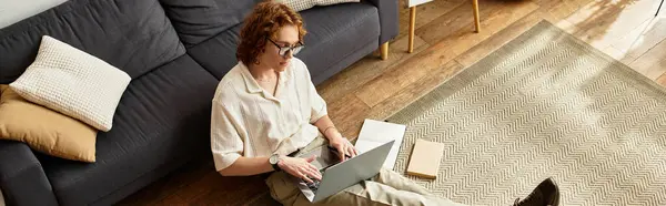 In a warm and inviting space, a young man is focused on his laptop, creating in comfort. — Stock Photo
