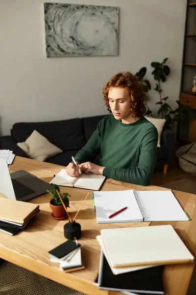 Young man concentrates on writing notes while surrounded by a comfortable home setting. — Stock Photo