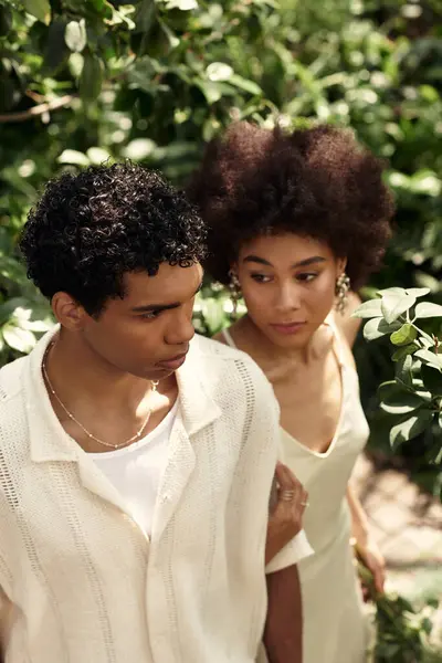Two young lovers enjoy each others company in a vibrant greenhouse filled with plants and life. — Stock Photo