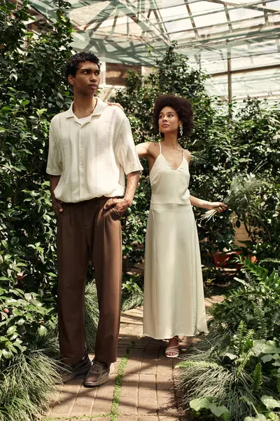 Couple embraces their love amid thriving plants, enjoying a serene moment in the greenhouse. — Stock Photo
