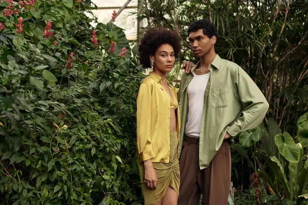 A young couple shares a tender moment together among vibrant plants in a serene greenhouse. — Stock Photo