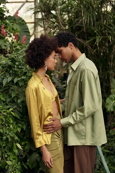 Couple embraces each other in a serene greenhouse filled with lush plants and vibrant colors. — Stock Photo