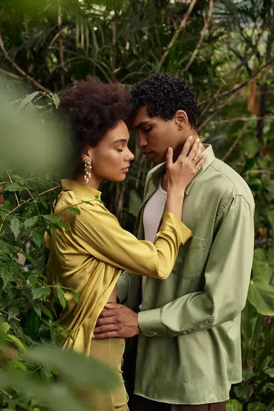 A young couple shares a tender moment in a greenhouse surrounded by flourishing plants and love. — Stock Photo
