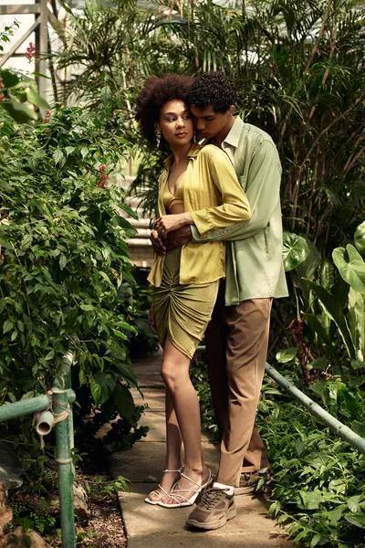 A couple embraces warmly amidst thriving plants, celebrating love in a peaceful greenhouse. — Stock Photo