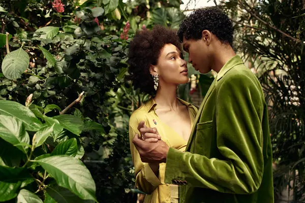 In a verdant greenhouse, a young couple embraces lovingly, lost in their own world of romance. — Stock Photo