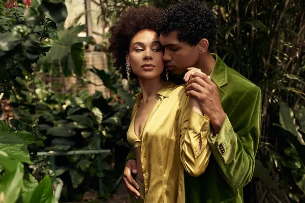 A young couple shares a tender moment surrounded by rich greenery in a cozy greenhouse. — Stock Photo