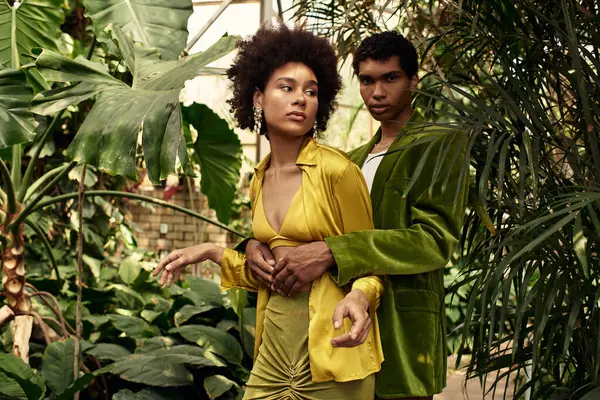 In a vibrant greenhouse, a young couple shares a romantic moment together. — Stock Photo