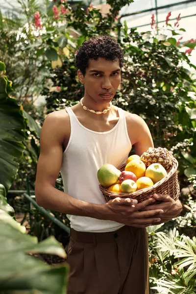 A young stylish man enjoys his time surrounded by lush plants, radiating love and happiness. — Stock Photo