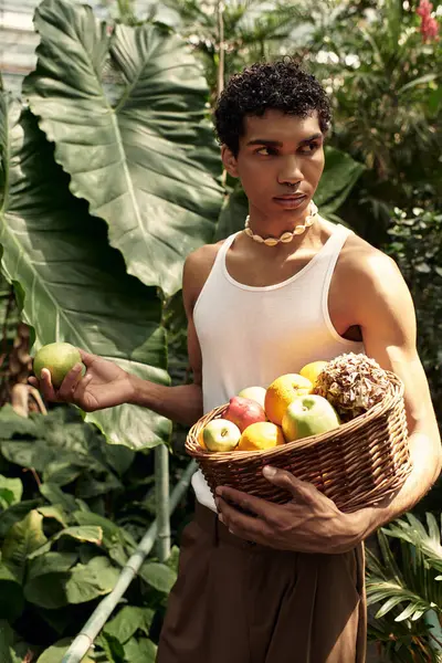 A young stylish man surrounded by vibrant plants in a peaceful greenhouse setting. — Stock Photo
