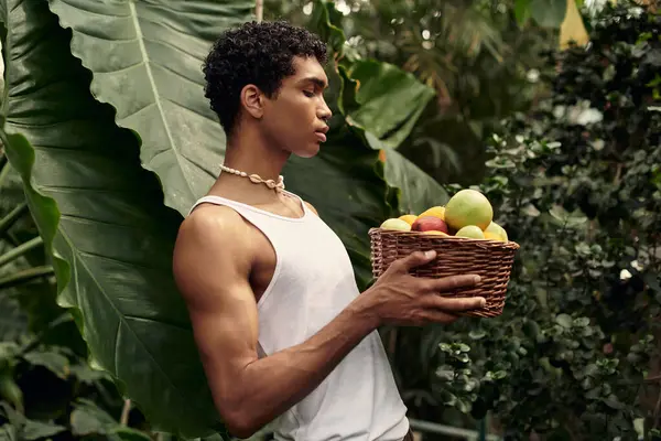 In a lush greenhouse, a man having a tender moment surrounded by greenery and fresh fruits. — Stock Photo