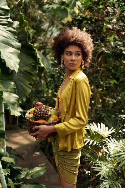 A pretty woman enjoys time in a lush greenhouse filled with greenery and plants. — Stock Photo