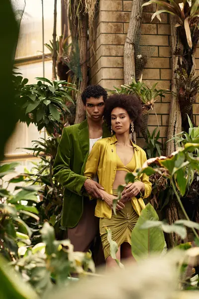 A romantic moment between a young couple unfolds surrounded by lush plants in a greenhouse. — Stock Photo