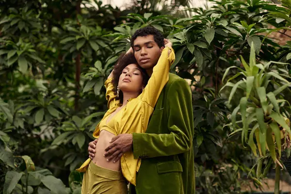 A young couple shares a tender moment surrounded by lush greenery in a greenhouse. — Stock Photo