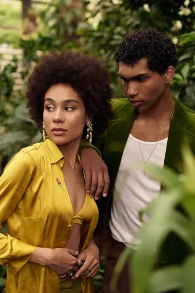 A young couple shares a tender moment amid vibrant plants in a peaceful greenhouse. — Stock Photo