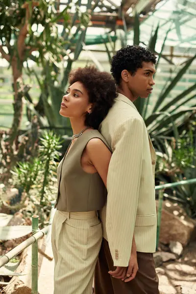 Couple enjoys intimate moment surrounded by vibrant greenery and flourishing plants. — Stock Photo