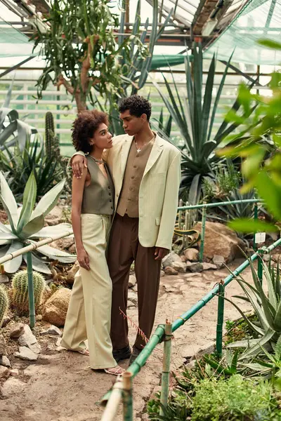 A couple embraces lovingly among vibrant plants, showcasing a serene moment surrounded by nature. — Stock Photo