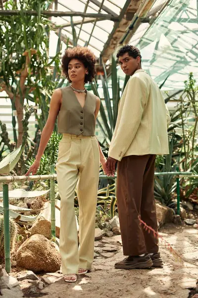 Couple embraces their love surrounded by vibrant plants in a serene greenhouse environment. — Stock Photo