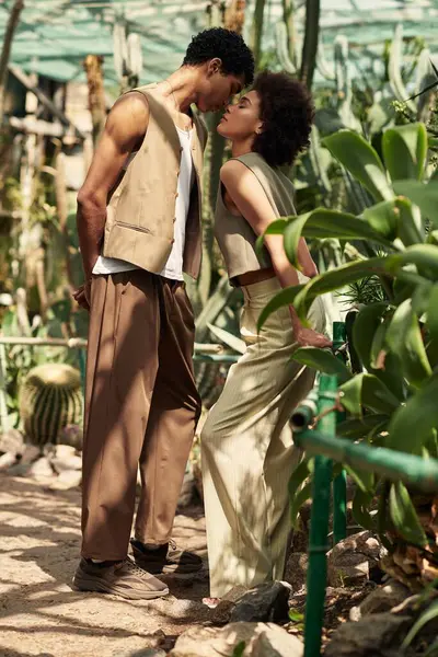 A loving couple connects deeply amid flourishing plants in a peaceful greenhouse setting. — Stock Photo