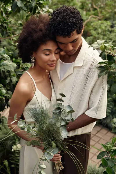 A couple embraces lovingly among vibrant plants, celebrating their connection and romance. — Stock Photo