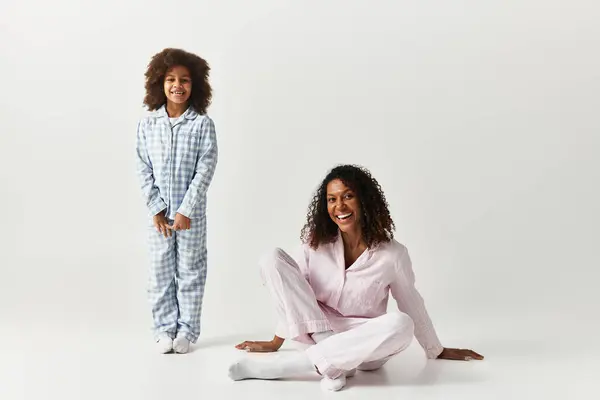 Nero mamma e figlia in corrispondenza pigiama sorriso in studio. — Foto stock