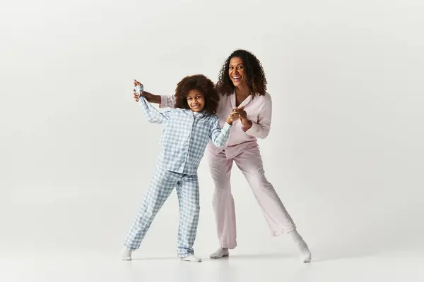 Preto mãe e filha no correspondência pjs brincalhão poses. — Fotografia de Stock