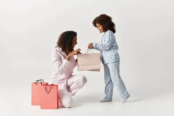 Matching PJs Black mother overjoyed with gift from daughter. — Stock Photo