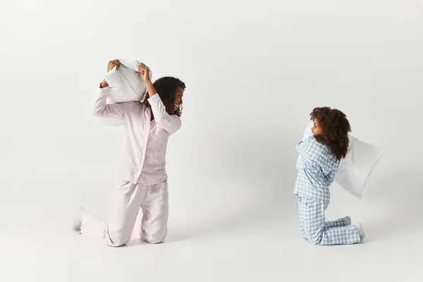 Nero madre e figlia cuscino lotta in corrispondenza pigiama avendo cuscino lotta — Foto stock