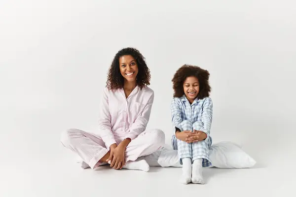 Nero madre e bambino in corrispondenza PJs sorriso sul pavimento. — Foto stock