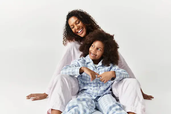 African American Mother and daughter, dressed in matching pyjamas, share a happy and loving moment. — Stock Photo
